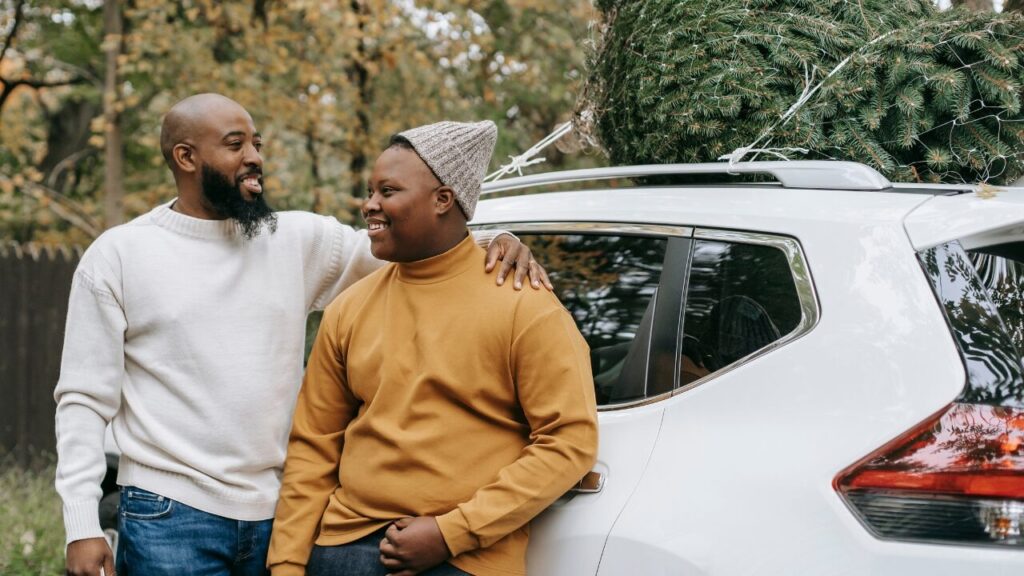 photo of father and son embracing beside a car. they are smiling.